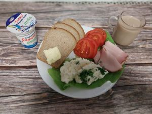 Zdjęcie przedstawia Dietę z ograniczeniem łatwoprzyswajalnych węglowodan&oacute;w: Masło extra Kawa zbożowa z mlekiem Chleb Graham Szynka pieczona na ogniu wieprzowa z dod.wodą, wędzona, pieczona, parzona Jogurt naturalny Sałata zielona Twarożek z natką pietruszki Pomidor